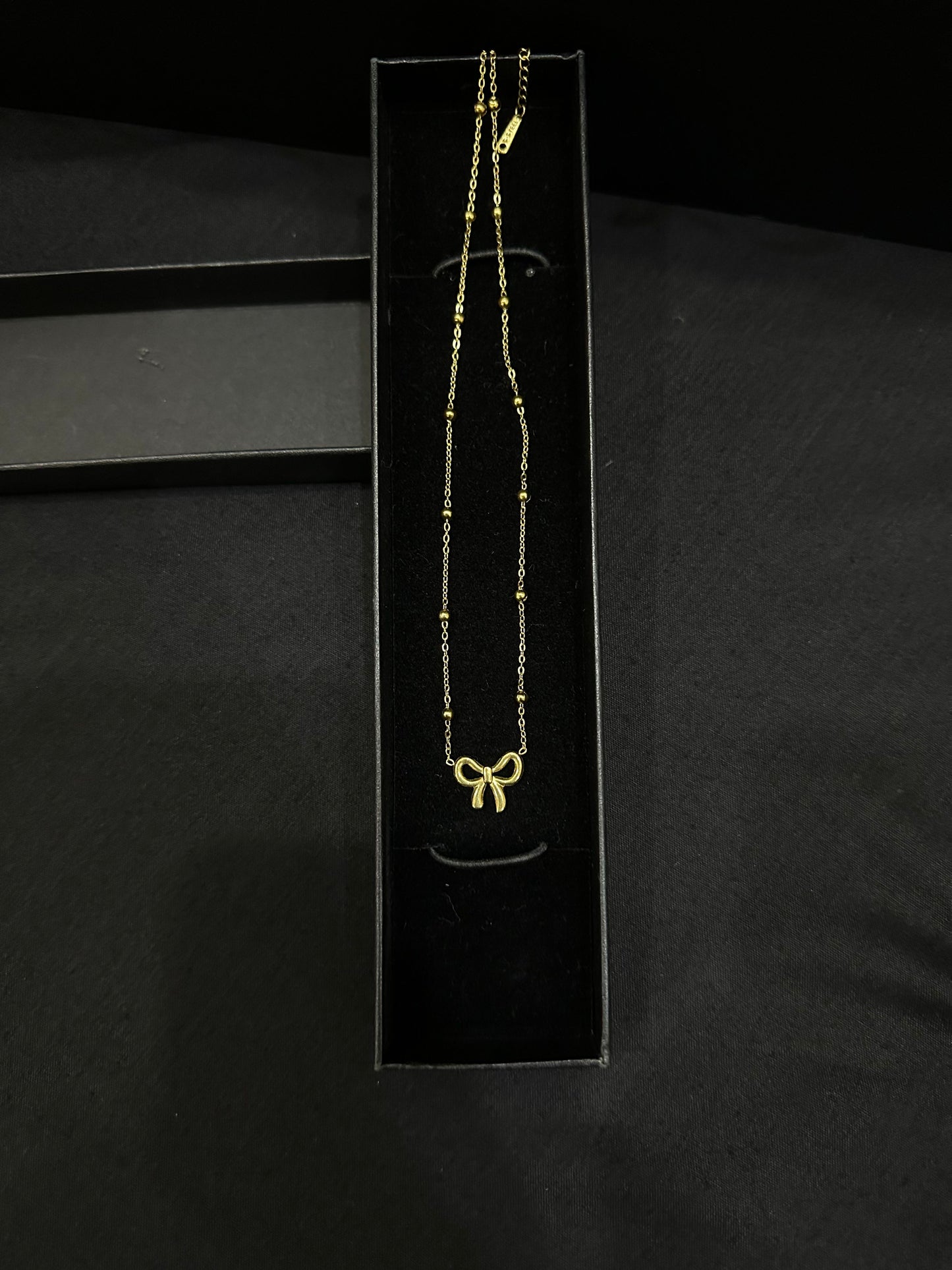 Golden Knot pendant by Zyro featuring a polished gold finish and intricate knot design, close-up view of the jewelry piece