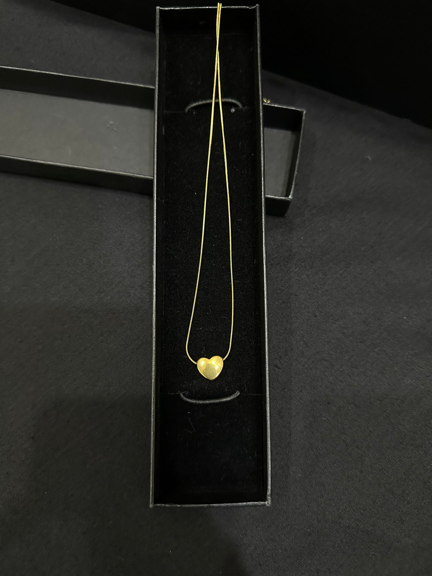 Gold heart pendant by Zyro featuring a polished, elegant design with a delicate chain and a shiny finish.