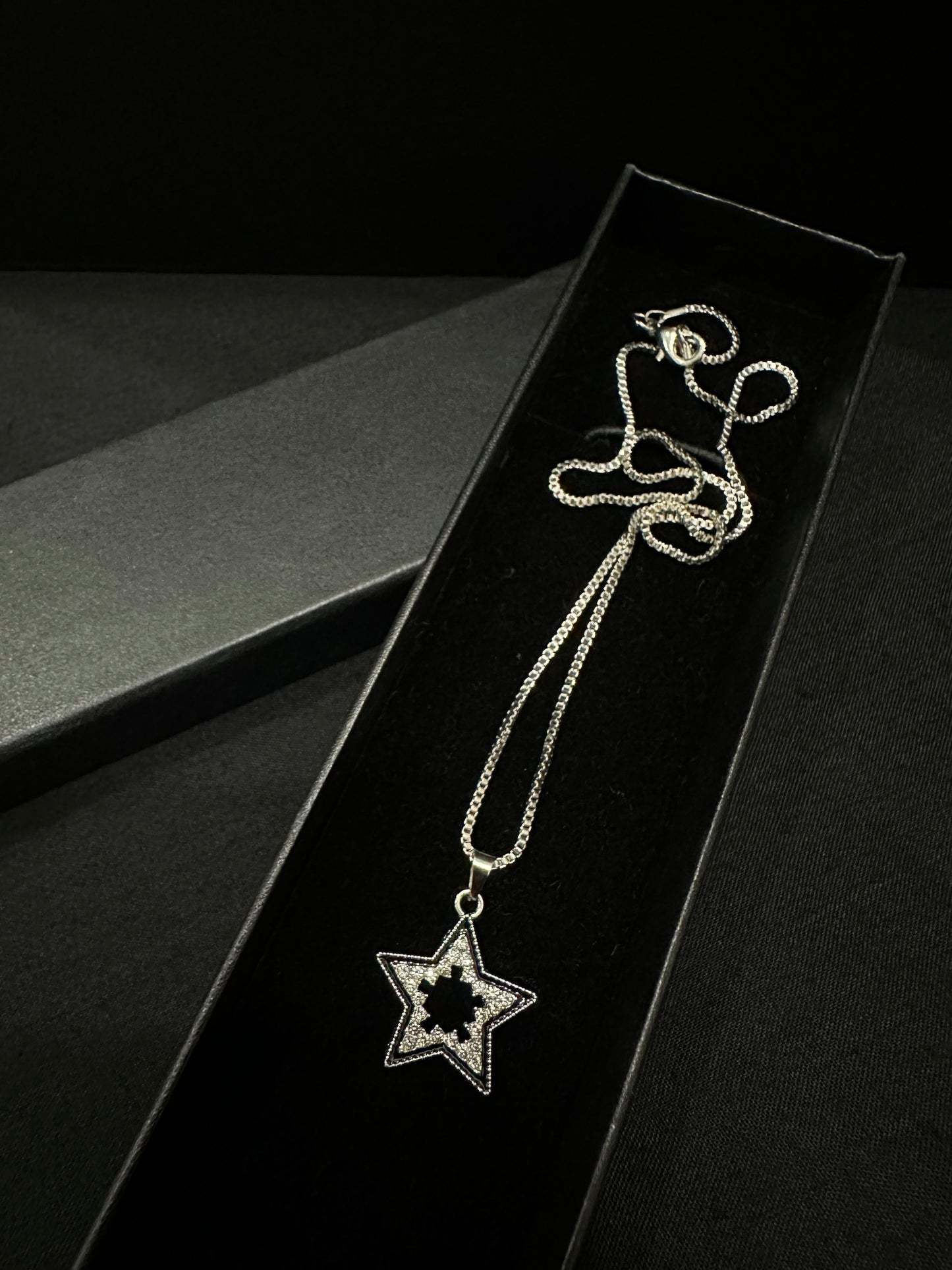 Silver celestial star pendant by Zyro featuring a detailed star design on a delicate chain.