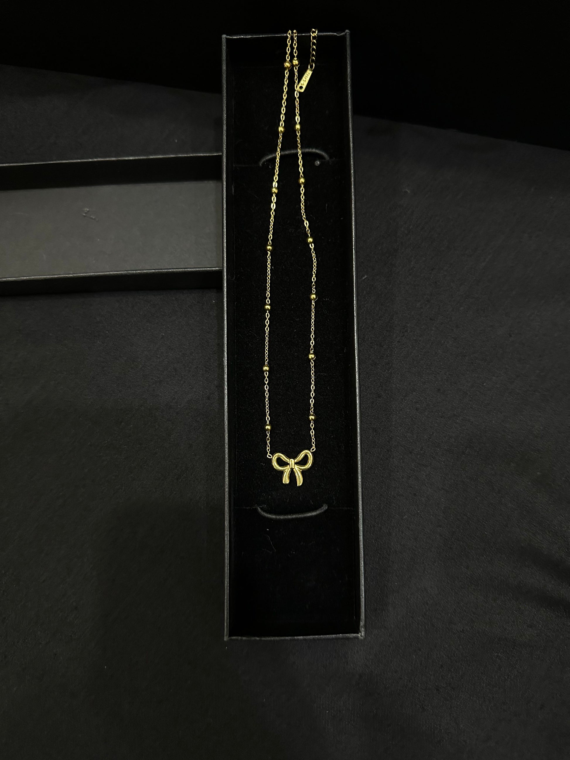 Golden Knot pendant by Zyro featuring a polished gold finish and intricate knot design, close-up view of the jewelry piece