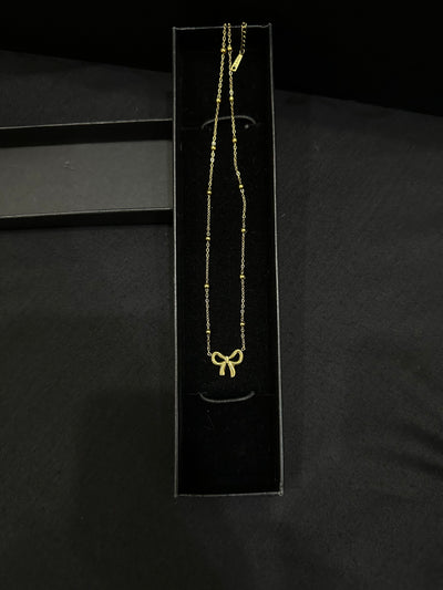 Golden Knot pendant by Zyro featuring a polished gold finish and intricate knot design, close-up view of the jewelry piece