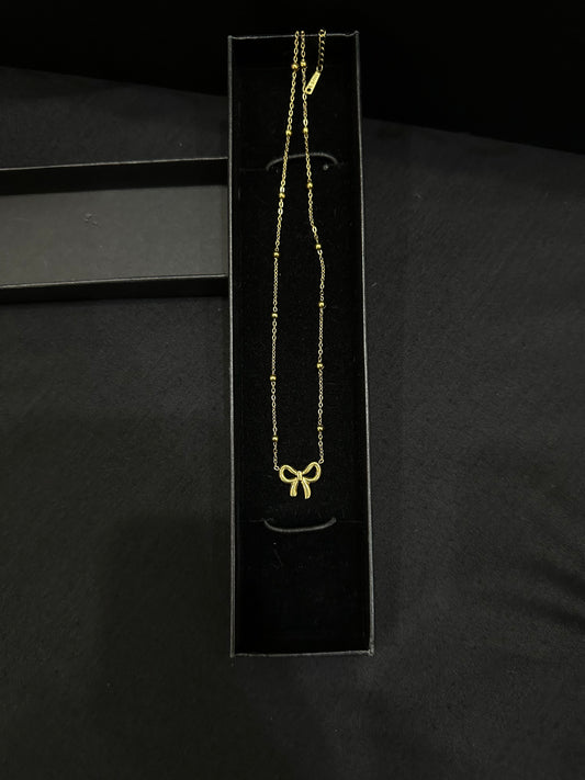 Golden Knot pendant by Zyro featuring a polished gold finish and intricate knot design, close-up view of the jewelry piece