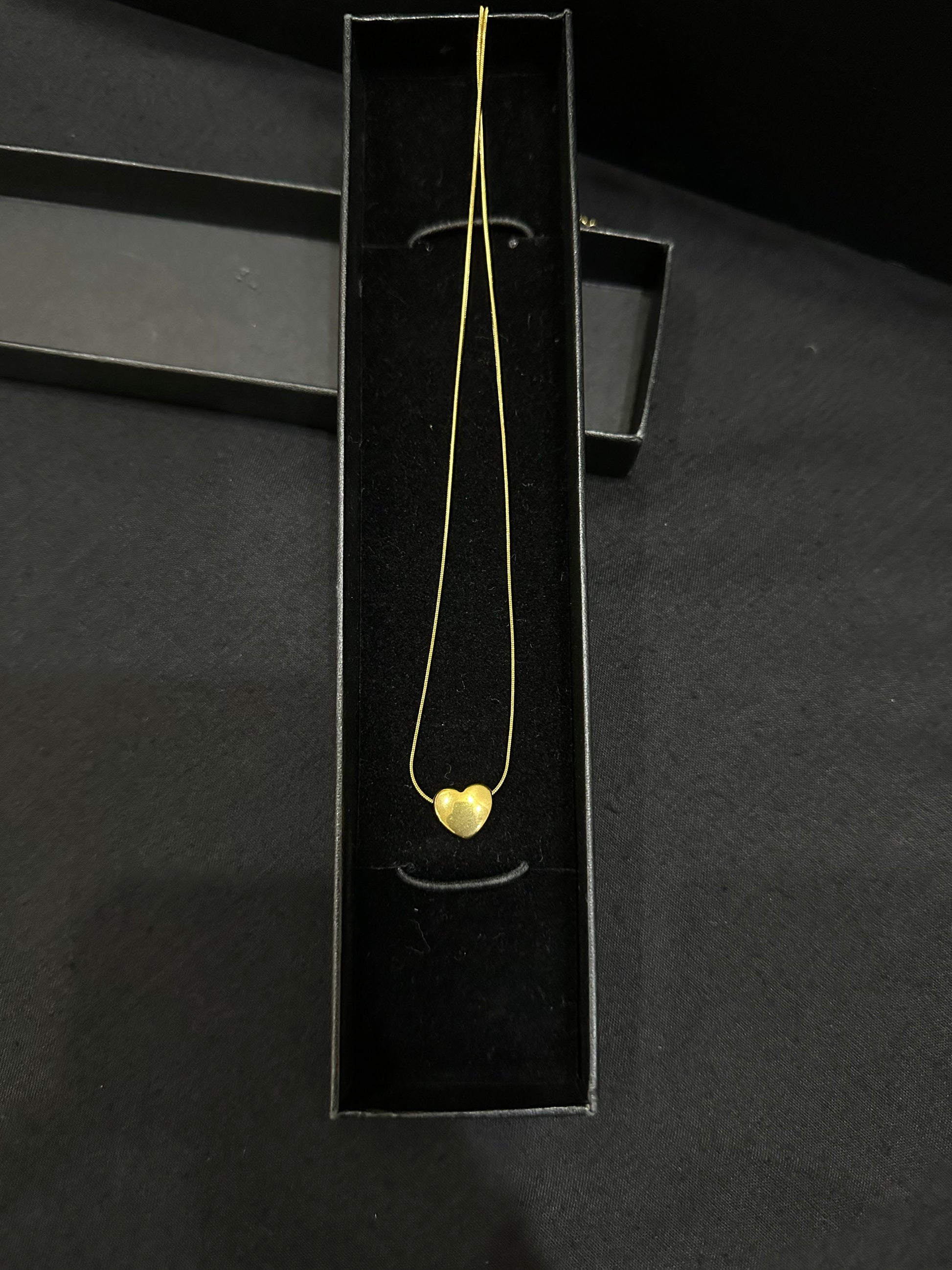 Gold heart pendant by Zyro featuring a polished, elegant design with a delicate chain and a shiny finish.