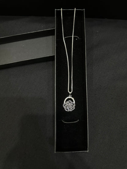 Silver rose pendant by Zyro featuring a detailed, polished rose design on a delicate chain, close-up view.