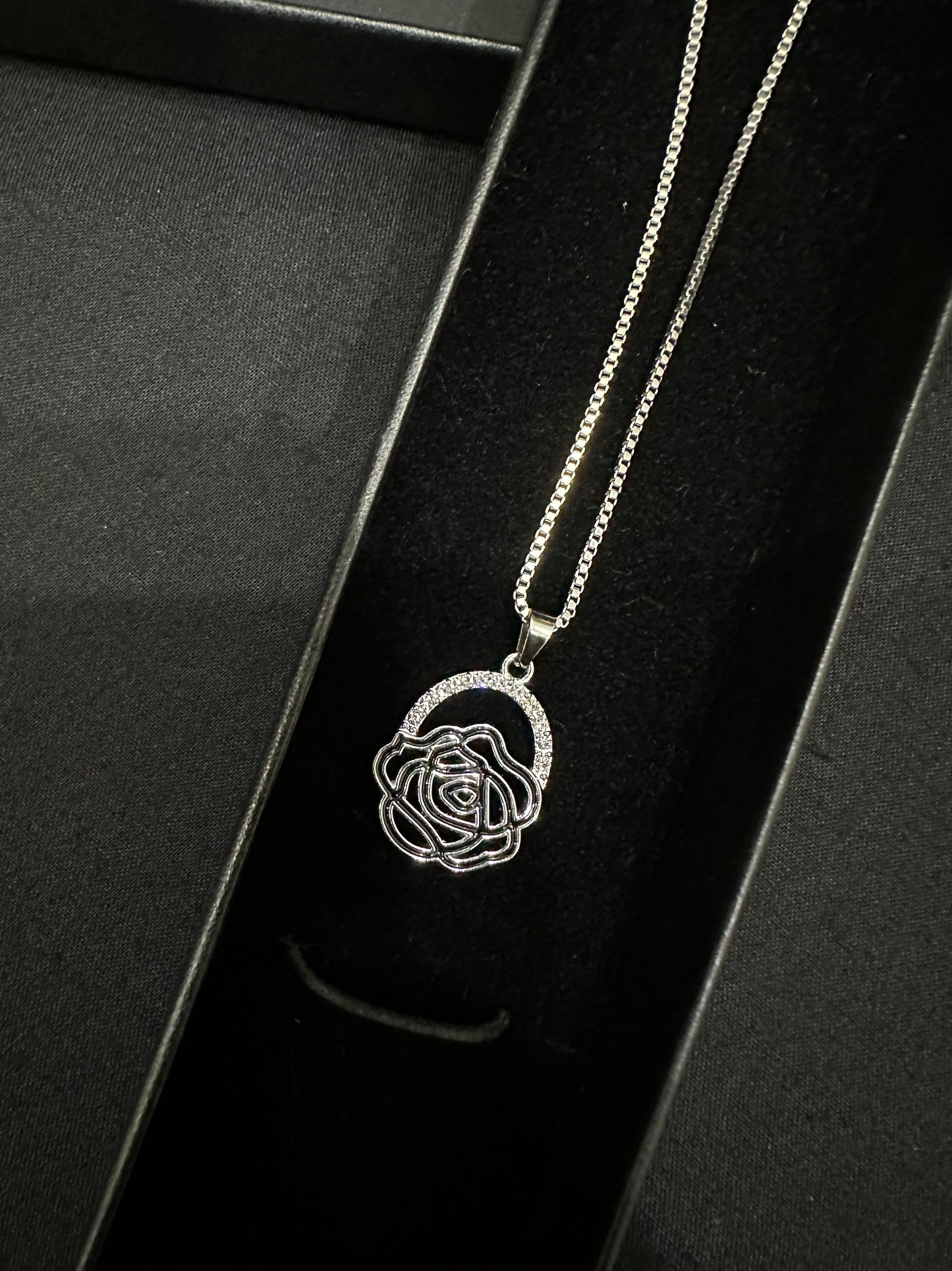 Silver rose pendant by Zyro featuring a detailed, elegant floral design on a sleek chain.