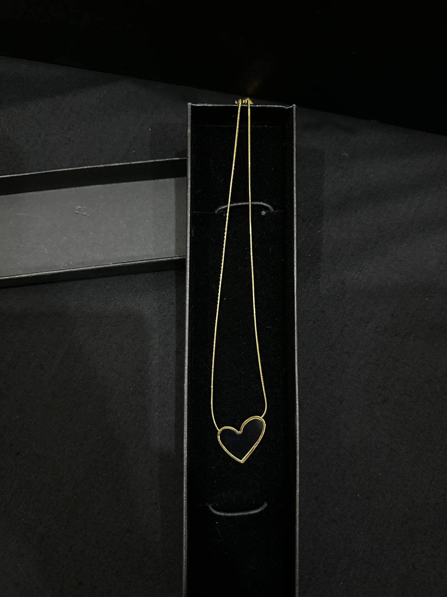 Black Luna Heart Pendant necklace by Zyro featuring a sleek heart-shaped design on a delicate chain.