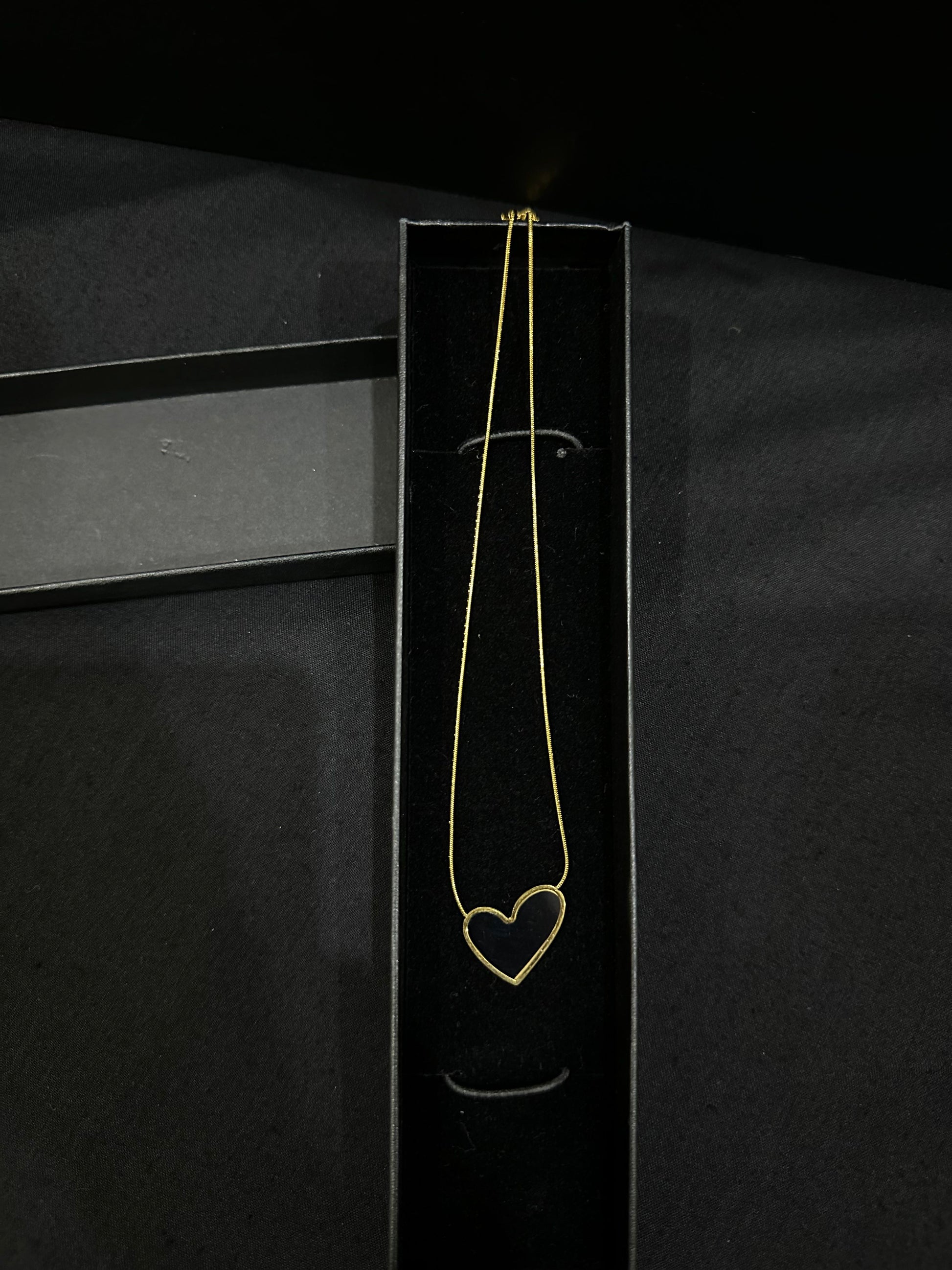 Black Luna Heart Pendant necklace by Zyro featuring a sleek heart-shaped design on a delicate chain.