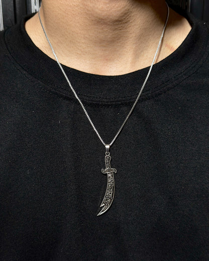 Zyro Zulfiqar Sword Pendant featuring a detailed metallic sword design on a chain, close-up view of the jewelry accessory.